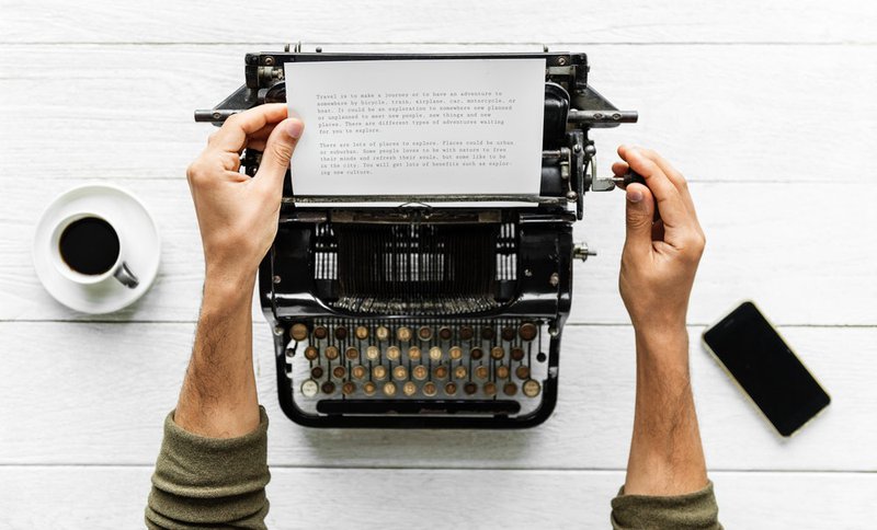 typewriter with a coffee and iPhone 