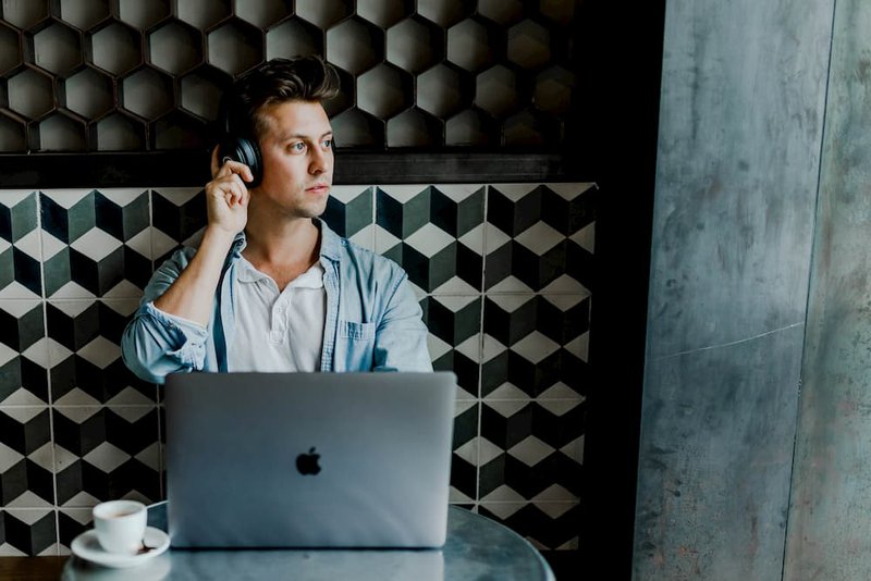 a man listening to music with his macbook pro